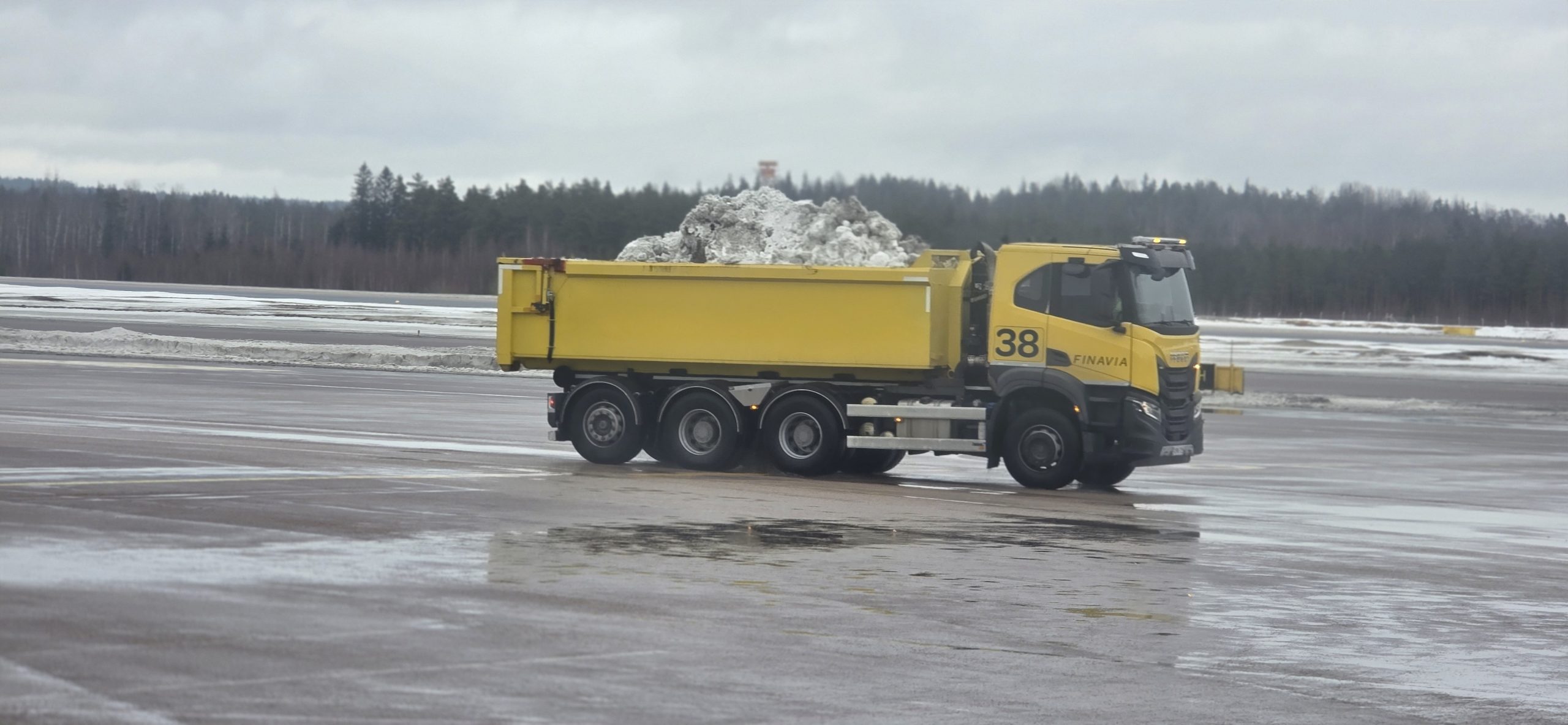Snow removal truck operating on airport apron surface